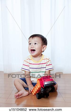 Stock Image - Baby Boy Playing With Toy Car. Fotosearch