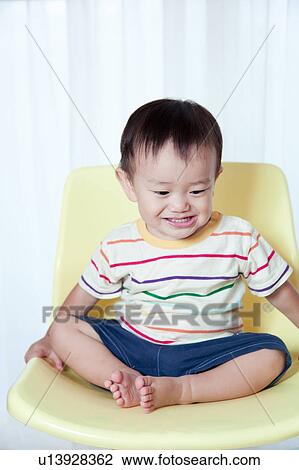 Stock Image - Baby Boy Sitting on Chair. Fotosearch