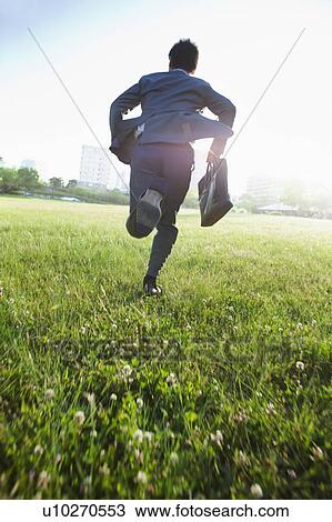 Stock Image - Businesman Running, Low Angle View. Fotosearch