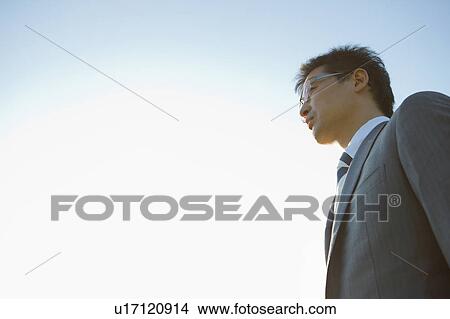 Businessman Against Sky, Low Angle View View Large Photo Image Picture - Businessman Against Sky, Low Angle View. Fotosearch