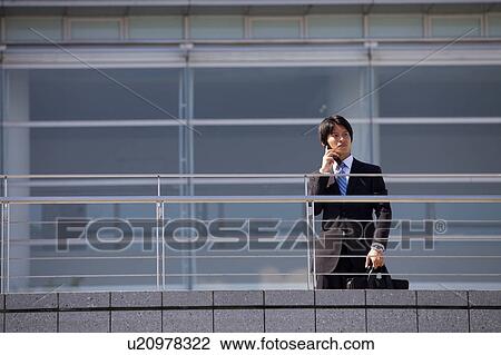 Stock Image - Businessman on cell phone, Shiga Prefecture, Honshu, Japan. Fotosearch