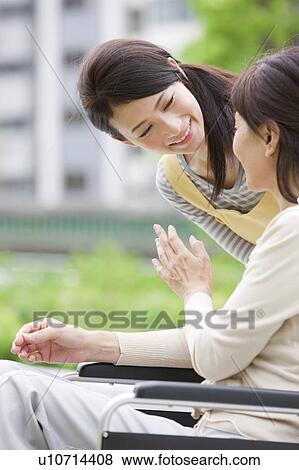 Caretaker and mature woman on wheelchair talking View Large Photo Image Stock Photo - Caretaker and mature woman on wheelchair talking. Fotosearch