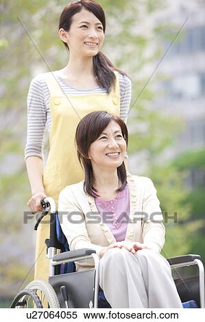 Caretaker pushing mature woman on wheelchair View Large Photo Image Stock Photography - Caretaker pushing mature woman on wheelchair. Fotosearch