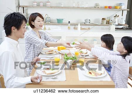 Stock Image - Family eating breakfast, Hyogo Prefecture, Honshu, Japan. Fotosearch