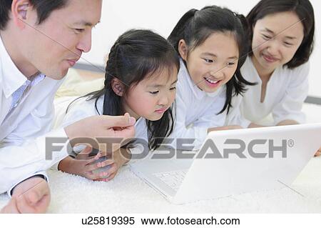 Stock Photography - Family of Four Using Laptop. Fotosearch