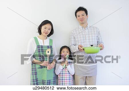 Stock Image - Family of Three Holding Cooking Utensils. Fotosearch
