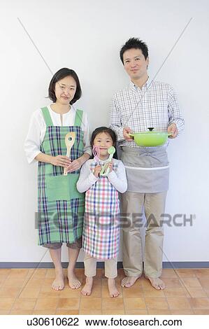 Stock Image - Family of Three Holding Cooking Utensils. Fotosearch