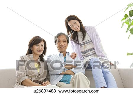 Stock Photo - Family sitting on sofa. Fotosearch