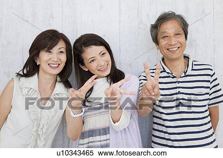 Family standing by the wall making peace sign View Large Photo Image Stock Photography - Family standing by the wall making peace sign. Fotosearch