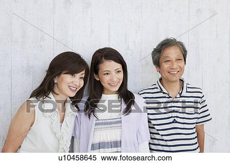 Family standing by the wall View Large Photo Image Stock Photography - Family standing by the wall. Fotosearch