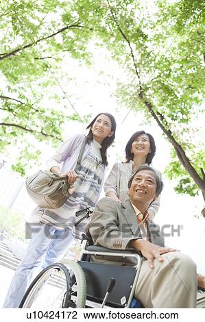 Stock Image - Family standing on sidewalk. Fotosearch