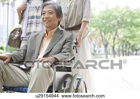 Family walking and pushing father on wheelchair View Large Photo Image Picture - Family walking and pushing father on wheelchair. Fotosearch