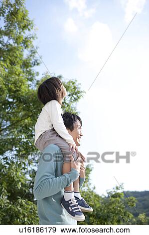 Stock Photo - Father carrying son on the shoulders. Fotosearch