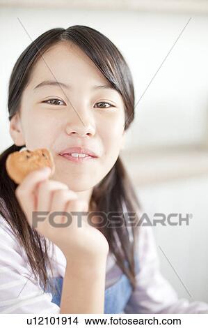Girl eating a cookie, Hyogo Prefecture, Honshu, Japan View Large Photo Image Picture - Girl eating a cookie, Hyogo Prefecture, Honshu, Japan. Fotosearch