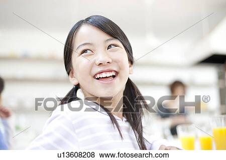 Stock Photo - Girls sitting in a chair, Hyogo Prefecture, Honshu, Japan. Fotosearch