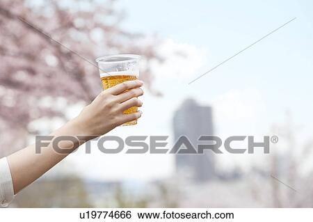 Hand holding beer in plastic cup View Large Photo Image Stock Photograph - Hand holding beer in plastic cup. Fotosearch