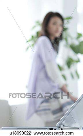 Laptop and woman in background View Large Photo Image Stock Image - Laptop and woman in background. Fotosearch