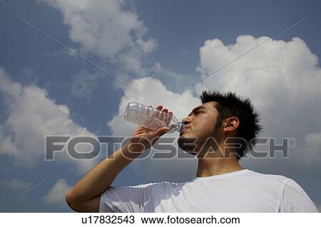Stock Image - Man drinking water, Kyoto Prefecture, Honshu, Japan. Fotosearch