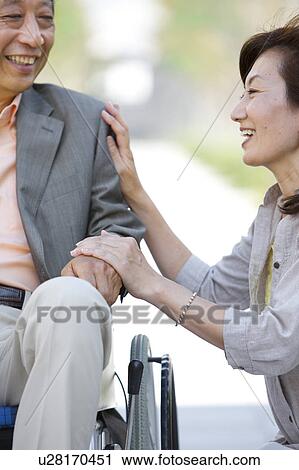 Mature woman and senior man on wheelchair holding hands View Large Photo Image Stock Image - Mature woman and senior man on wheelchair holding hands. Fotosearch
