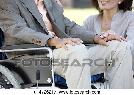Mature woman and senior man on wheelchair holding hands View Large Photo Image Stock Photo - Mature woman and senior man on wheelchair holding hands. Fotosearch