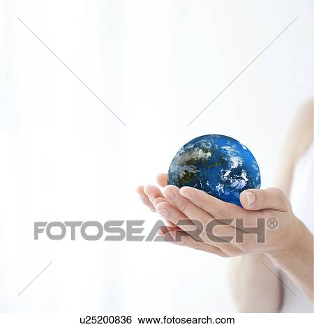 Stock Photograph - Mature woman holding planet earth, digital composite. Fotosearch