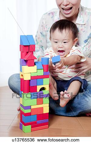 Stock Photograph - Mother and Baby Boy Playing With Toy Blocks. Fotosearch