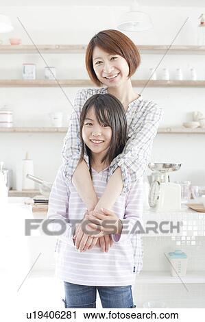 Stock Image - Mother and daughter in kitchen, Hyogo Prefecture, Honshu, Japan. Fotosearch