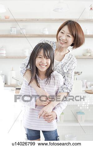 Stock Photo - Mother and daughter in kitchen, Hyogo Prefecture, Honshu, Japan. Fotosearch