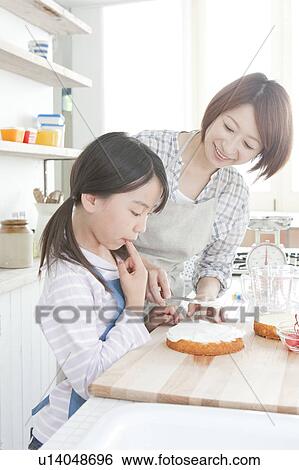 Mother and daughter in kitchen decorating cake, Hyogo Prefecture, Honshu, Japan View Large Photo Image Stock Photograph - Mother and daughter in kitchen decorating cake, Hyogo Prefecture, Honshu, Japan. Fotosearch