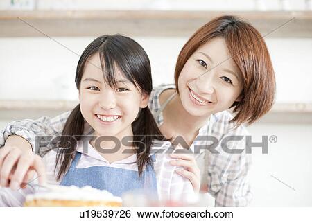 Mother and daughter in kitchen decorating cake, Hyogo Prefecture, Honshu, Japan View Large Photo Image Stock Photograph - Mother and daughter in kitchen decorating cake, Hyogo Prefecture, Honshu, Japan. Fotosearch