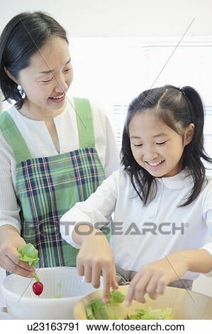 Stock Image - Mother and Daughter Preparing Salad. Fotosearch
