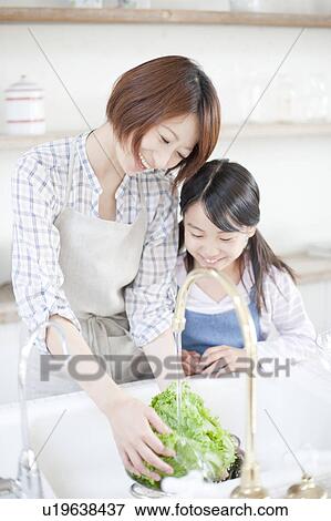 Stock Photo - Mother and daughter washing lettuce, Hyogo Prefecture, Honshu, Japan. Fotosearch