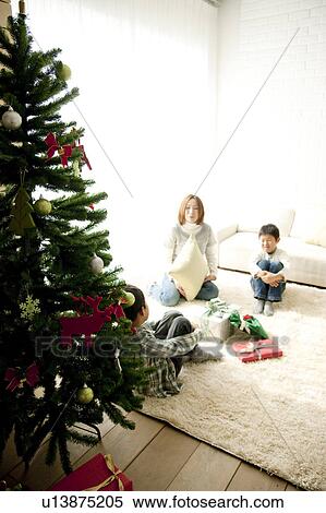 Mother and Two Children Sitting on Floor by Christmas Tree View Large Photo Image Stock Photography - Mother and Two Children Sitting on Floor by Christmas Tree. Fotosearch