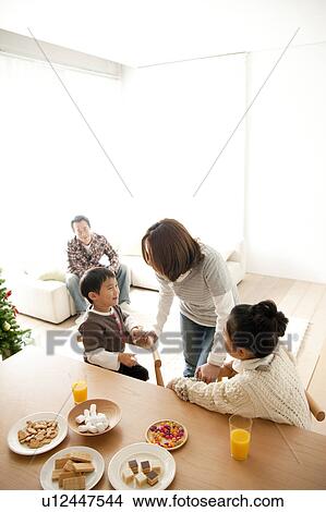 Picture - Mother, Daughter and Son at Dining Table at Christmas. Fotosearch