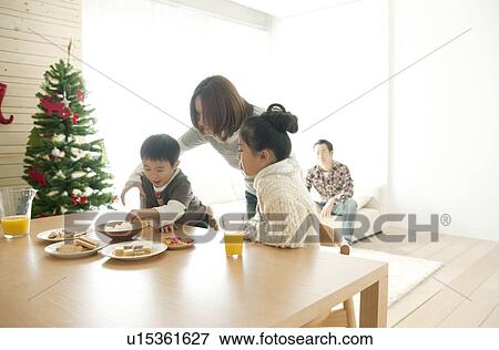 Stock Photo - Mother Watching Son and Daughter Eating. Fotosearch