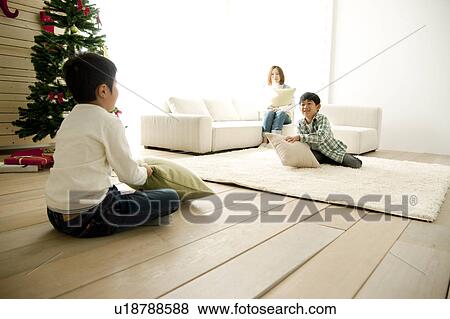 Mother Watching Two Sons Sitting on Floor with Cushions View Large Photo Image Stock Photo - Mother Watching Two Sons Sitting on Floor with Cushions. Fotosearch