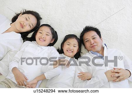 Picture - Parents and Two Daughters Lying on Back. Fotosearch