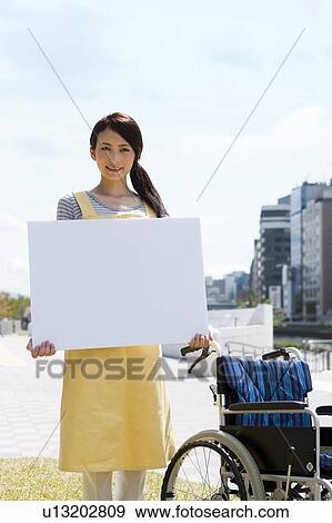 Portrait of caretaker holding a whiteboard View Large Photo Image Stock Photo - Portrait of caretaker holding a whiteboard. Fotosearch