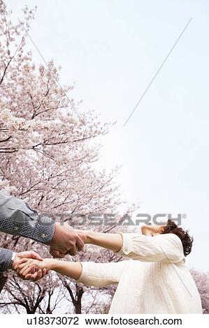 Rear view of couple holding hands, low angle view View Large Photo Image Stock Image - Rear view of couple holding hands, low angle view. Fotosearch
