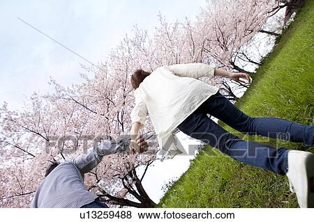 Stock Photo - Rear view of couple holding hands, rear view. Fotosearch