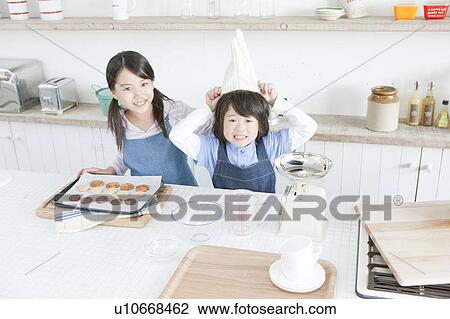 Stock Image - Sister and brother baking cookies, Hyogo Prefecture, Honshu, Japan. Fotosearch