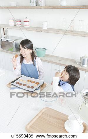 Stock Photography - Sister and brother eating cookies, Hyogo Prefecture, Honshu, Japan. Fotosearch