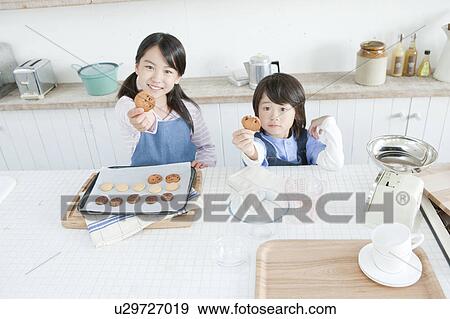 Stock Photo - Sister and brother holding cookies, Hyogo Prefecture, Honshu, Japan. Fotosearch