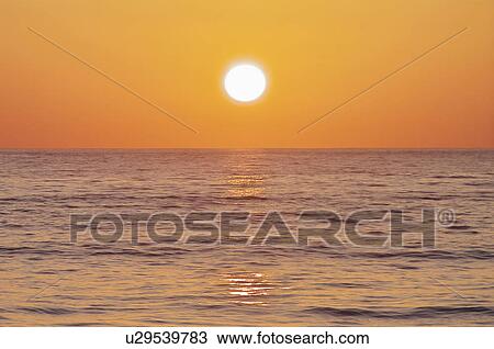 Stock Image - Sun Setting Over Sea. Fotosearch