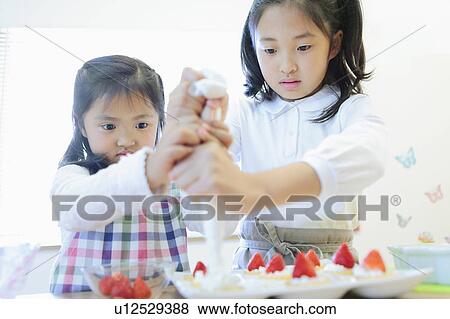 Two Girls Making Cakes View Large Photo Image Stock Photo - Two Girls Making Cakes. Fotosearch