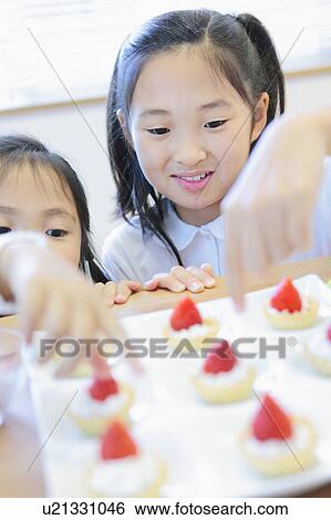 Two Girls Making Cakes View Large Photo Image Stock Photograph - Two Girls Making Cakes. Fotosearch