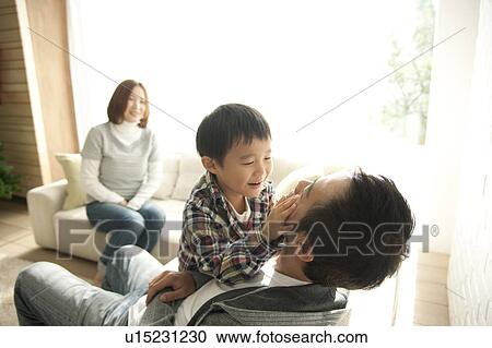 Two Parents and Son in Living Room at Christmas View Large Photo Image Stock Image - Two Parents and Son in Living Room at Christmas. Fotosearch