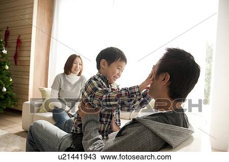 Two Parents and Son in Living Room at Christmas View Large Photo Image Stock Image - Two Parents and Son in Living Room at Christmas. Fotosearch