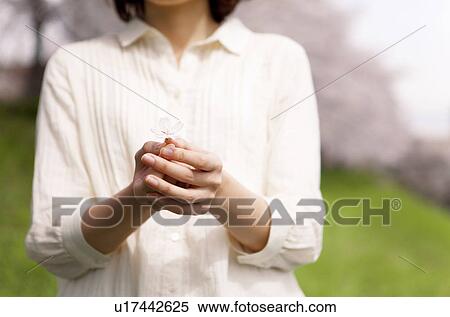 Stock Photography - Woman holding cherry blossom. Fotosearch