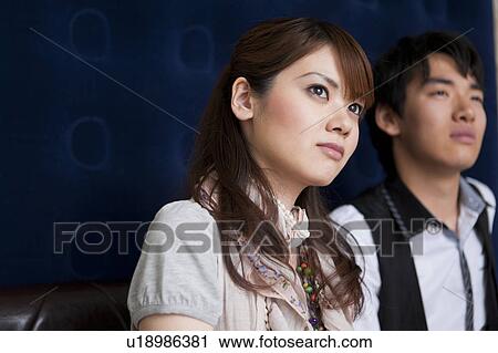 Young couple sitting on sofa View Large Photo Image Stock Image - Young couple sitting on sofa. Fotosearch